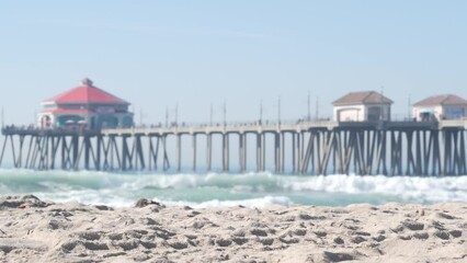 Wall Mural - Retro huntington pier, surfing in ocean waves and sandy beach, California coast near Los Angeles, USA. American diner, sea water, beachfront boardwalk, summer vacations. Seamless looped cinemagraph.