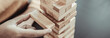 Business growth with wooden blocks concept, Planning to Reduce Investment Risks with Wooden Game Models, hand of a business woman placed a wooden block on a high tower,Management of limited resources.