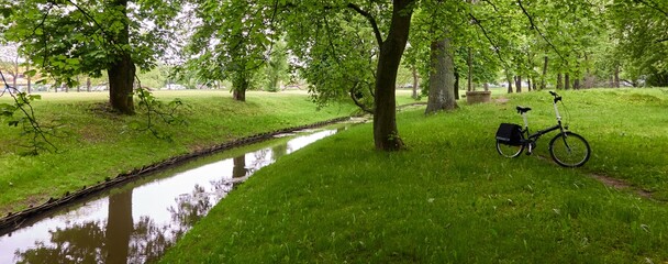 Bicycle parked on a green lawn in a city forest park. Spring, early summer. Recreation, leisure activity. sport, cycling, walking, healthy lifestyle themes