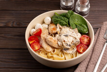On A Wooden Table, A Plate With Pasto1 Fettuccine With Chicken In Creamy Mushroom Sauce