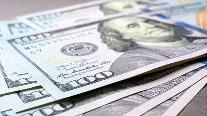 Wall Mural - american paper money. several one hundred dollar banknotes lie on a gray textured surface. focus on 
