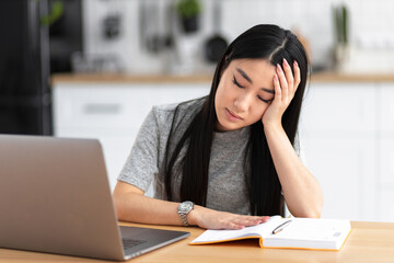 Portrait of sleeping Asian woman sitting at the table fell asleep from overwork from long work at computer Young female student tired, fell asleep in front of laptop after long study online education