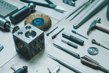 Equipment and tools of a goldsmith on metal background.