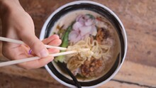 Popular Asian Food Ramen In The Restaurant. Simple And Delicious Asian Noodles Traditional Food With Vegetables And Meat. Ramon Noodles Are Eaten Using Chopsticks In A Street Restaurant.