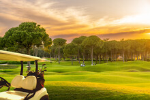 Golf Cart On Beautiful Golf Course At Sunset