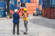 © Art_Photo - Professional engineer container cargo foreman in helmets working standing and using walkie talkie checking stock into container for loading.logistic transport and business industry export