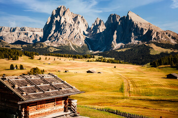 Alpe di Siusi - Seiser Alm with Sassolungo - Langkofel mountain group. Alpe di Siusi. Wonderful hiking nature scenery in dolomites. wooden chalets in Dolomites, Trentino Alto Adige