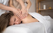 © Andrii Lysenko - Woman having four hands massage, female hands massaging girl's shoulders, relaxing massage training, masseur work concept