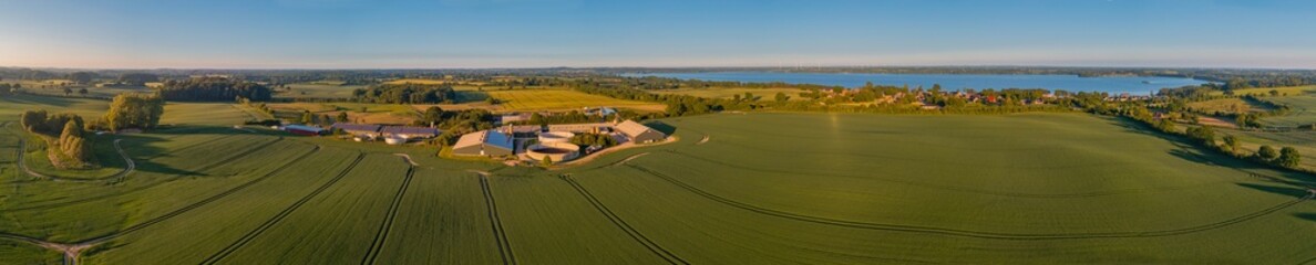 Wall Mural - Panorama aerial view of countryside with biogas plant with tanks with liquid manure. Aerial view of fields with agricultural factory with slurry tanks, modern grain silos. 