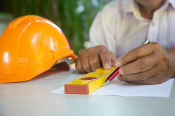 architect working of a blueprint model with pen at office. Closeup of hands