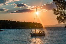 Sunset Over A Sailboat In A Little Bay