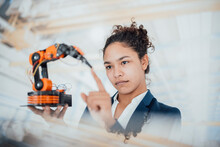 Businesswoman Touching Robotic Arm In Factory