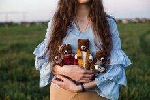 Woman Holding Handmade Teddy Bears Standing In Field