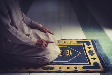 Wall Mural - religious muslim man pray on prayer cloth in mosque,gester of prayer,concept for rite in islam,workship,religion