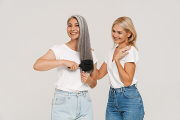 Wall Mural - Mature multiracial women wearing t-shirts brushing hair together