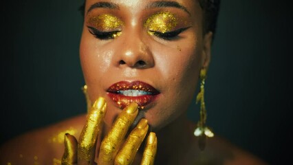 Wall Mural - closeup beauty art portrait fantastic golden professional makeup african woman, lips skin hands with paint drops liquid gold. Fashion model sexy face goddess. Glitter shadow eyes glow glitter shine.
