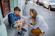 © Halfpoint - Mother consoling her little son on his first day of school,sitting on stairs and saying goodbye before school.