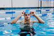 © Marcos - hispanic young man swimmer athlete wearing cap and goggles in a swimming training at the Pool in Mexico Latin America