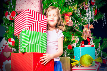 Wall Mural - Joyful girl with a large stack of gift boxes stands