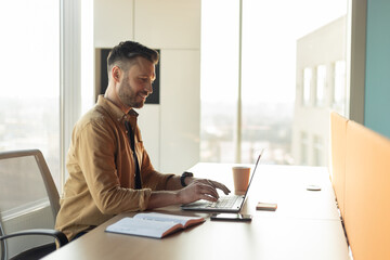 Poster - Side View Shot Of Businessman Typing On Laptop At Workplace