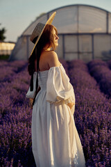 Wall Mural - the pregnant girl with a hat in the lavender field on a sunset