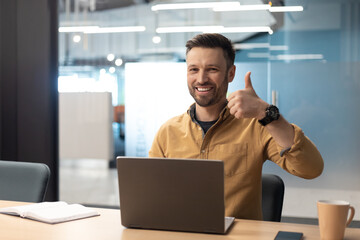 Poster - Business Man Gesturing Thumbs Up Using Laptop In Modern Office