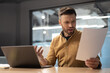© Prostock-studio - Shocked Businessman Holding Papers Having Issue Sitting In Modern Office