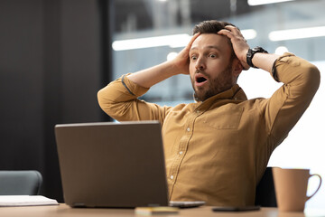 Poster - Shocked Male Looking At Laptop In Shock Sitting In Office