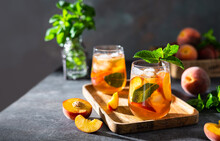 Refreshing Iced Tea With Ripe Peaches On Dark Background. Delicious Peach Iced Tea Cuba Libre Or Long Island Iced Tea Cocktail In Glasses. Summer Cold Fruit Drink. Copy Space Or Product Place