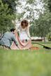 © LIGHTFIELD STUDIOS - happy young couple in summer clothes putting picnic blanket on green grass in park.