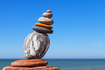 Wall Mural - The fall of the pyramid of balanced stones on blue sky background. .