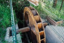 High Angle Shot Of An Old Wooden Waterwheel In A Garden