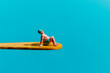 miniature man sitting on a yellow diving board
