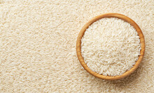 Wooden Plate With Basmati Rice On A Long Rice Background Close-up Top View.