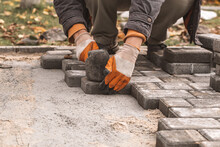 Laying Paving Slabs Close-up. Road Surface, Construction. Sidewalk Repair. Worker Laying Stone Paving Slab. Laying Tiles In The City Park Garden . Manual Fixed Tessellated Paving Slabs