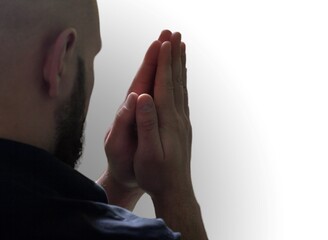 A faithful young male hands in prayer gesture sitting alone pray and hope for good luck, success, forgiveness. Power of religion, belief, god faith, worship concept ideas.