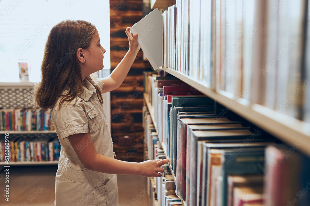 Schoolgirl choosing book in school library. Smart girl selecting books. Learning from books. School education. Benefits of everyday reading. Child curiosity. Back to school