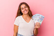 © Asier - Young caucasian woman holding bills isolated on pink background  happy, smiling and cheerful.