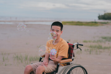 Wall Mural - Blur of young man with disability playing bubble shooter toy gun.A practice of using hand and finger muscles through play.One form of occupational therapy practice that develops good emotional skills.