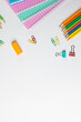 © vectorfusionart - Vertical composition of notebooks, clips and crayons on white surface with copy space