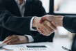 © kamiphotos - Close-up two business men holding hands, Two businessmen are agreeing on business together and shaking hands after a successful negotiation. Handshaking is a Western greeting or congratulation.