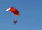 Fototapeta  - Aircraft with a red parachute and an engine controlled by the pilot.copy space