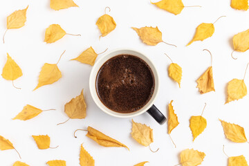 Cup of coffee and autumn yellow dry leaves.