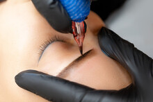 Close-up Master Makes Eyebrow Tattoo Apply Permanent Makeup On The Model's Eyebrows