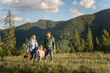 © rh2010 - Young caucasian couple with little girl walk together while traveling in the mountains. Happy family spending summer vacation on nature