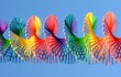 Closeup of an open slinky spring rainbow circle against blue sky background