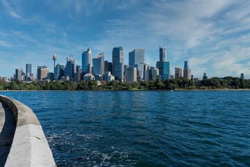 Wall Mural - View of the blue sea and city buildings on the shore. Sydney skyline, Australia.