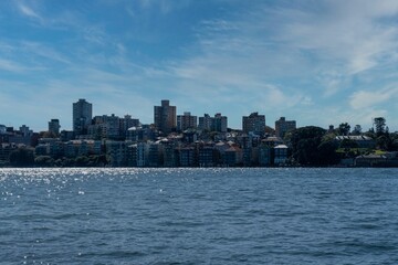 Wall Mural - View of the blue sea and city buildings on the shore. Sydney, Australia.