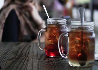 Sticker - Closeup shot of two refreshing iced lemon tea with spoons on a table