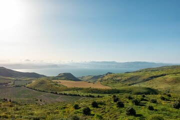 Beautiful countryside summer landscape with green vale and hills against the blue sky and lake.